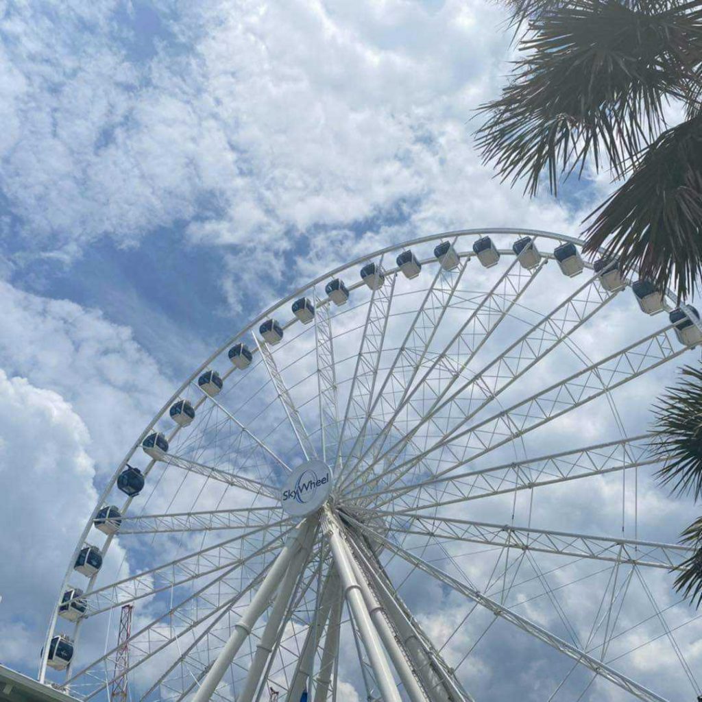 Clouds in sky with Myrtle Beach SkyWheel and gondolas.